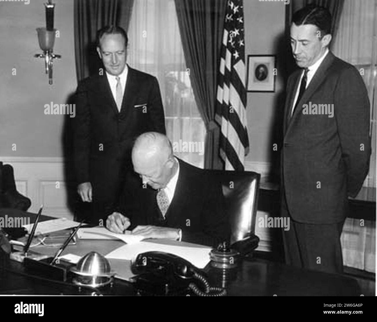 William Rogers und Lawrence Walsh sind Zeugen der DDE, die das Gesetz über Bürgerrechte unterzeichnen. Stockfoto