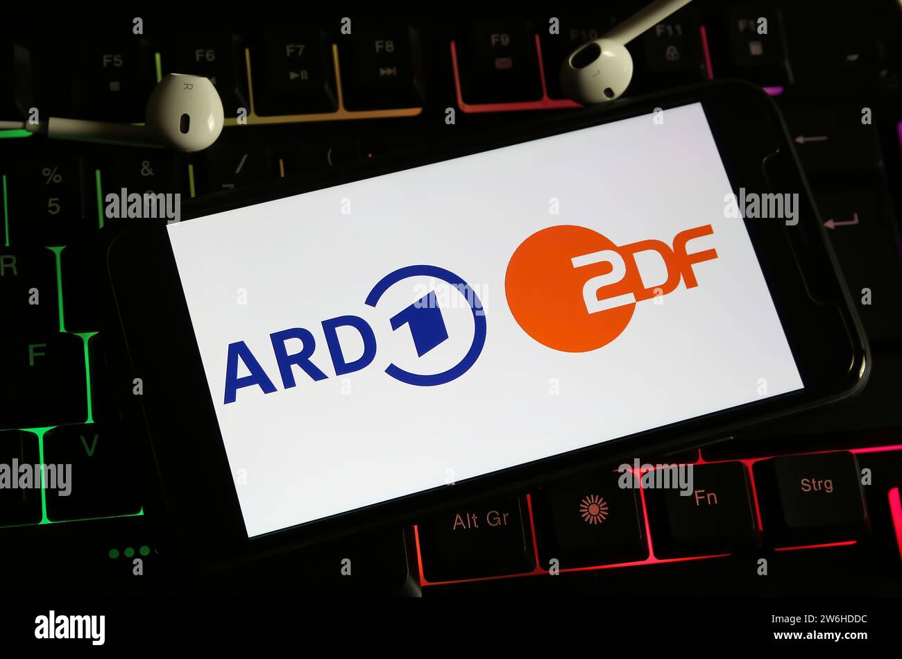 Viersen, Deutschland - 9. Dezember. 2023: Nahaufnahme des Smartphones auf Computertastatur mit Logobeschriftung der öffentlich-rechtlichen Fernsehsender ARD und ZDF Stockfoto