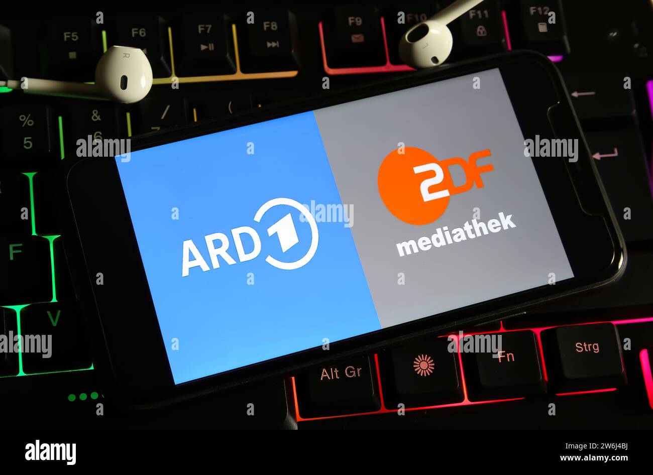 Viersen, Deutschland - 9. Dezember. 2023: Nahaufnahme des Smartphones auf Computertastatur mit Logobeschriftung der öffentlich-rechtlichen Fernsehsender ARD und ZDF Stockfoto