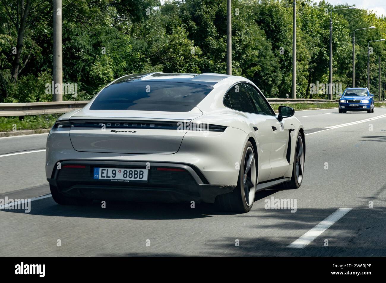 OSTRAVA, TSCHECHISCHE REPUBLIK - 10. AUGUST 2023: Graue Porsche Taycan 4S elektrische Limousine fährt schnell mit Bewegungsunschärfe Stockfoto