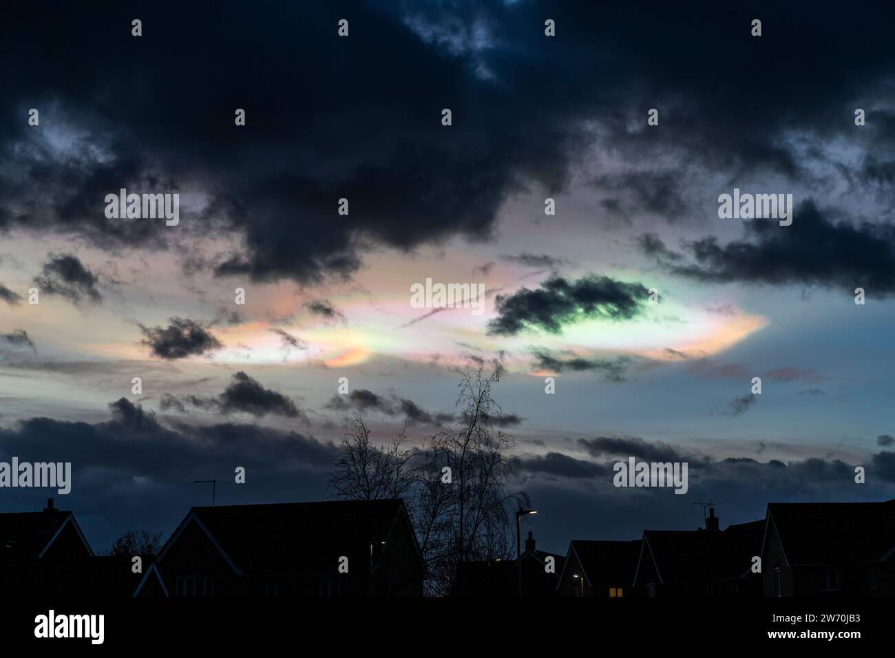 Nacreous, oder Perlmutt, Wolken über Südostengland. Hoch oben in der Stratosphäre reflektieren diese polaren schillernden Wolken das Sonnenlicht, die untergehende Sonne befindet sich normalerweise an diesem Punkt unterhalb des Horizonts. Sie sind sehr selten über England, da sie hauptsächlich polare Luft aus dem arktischen Kreis verdrängt haben. Stockfoto