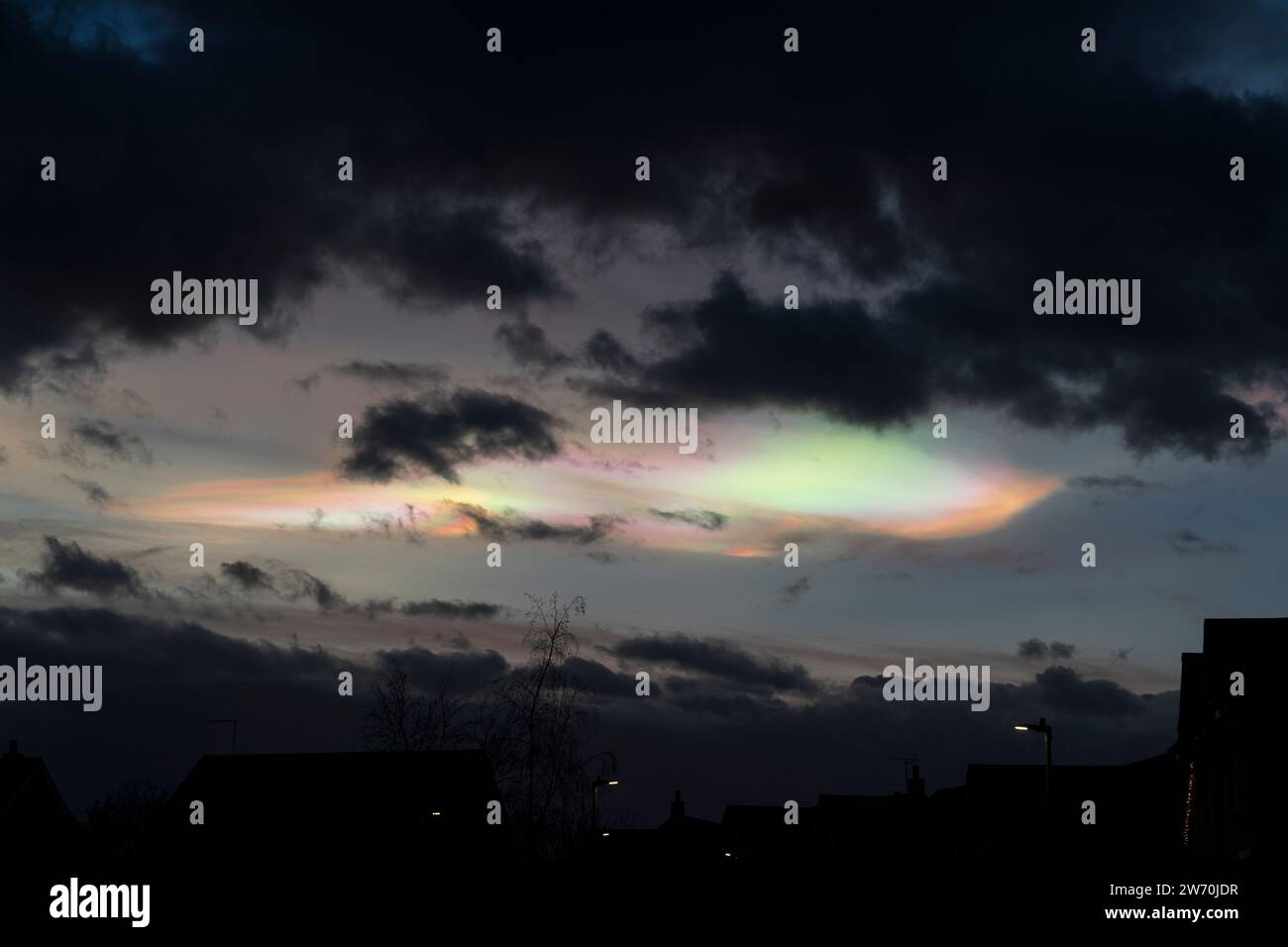 Nacreous, oder Perlmutt, Wolken über Südostengland. Hoch oben in der Stratosphäre reflektieren diese polaren schillernden Wolken das Sonnenlicht, die untergehende Sonne befindet sich normalerweise an diesem Punkt unterhalb des Horizonts. Sie sind sehr selten über England, da sie hauptsächlich polare Luft aus dem arktischen Kreis verdrängt haben. Stockfoto