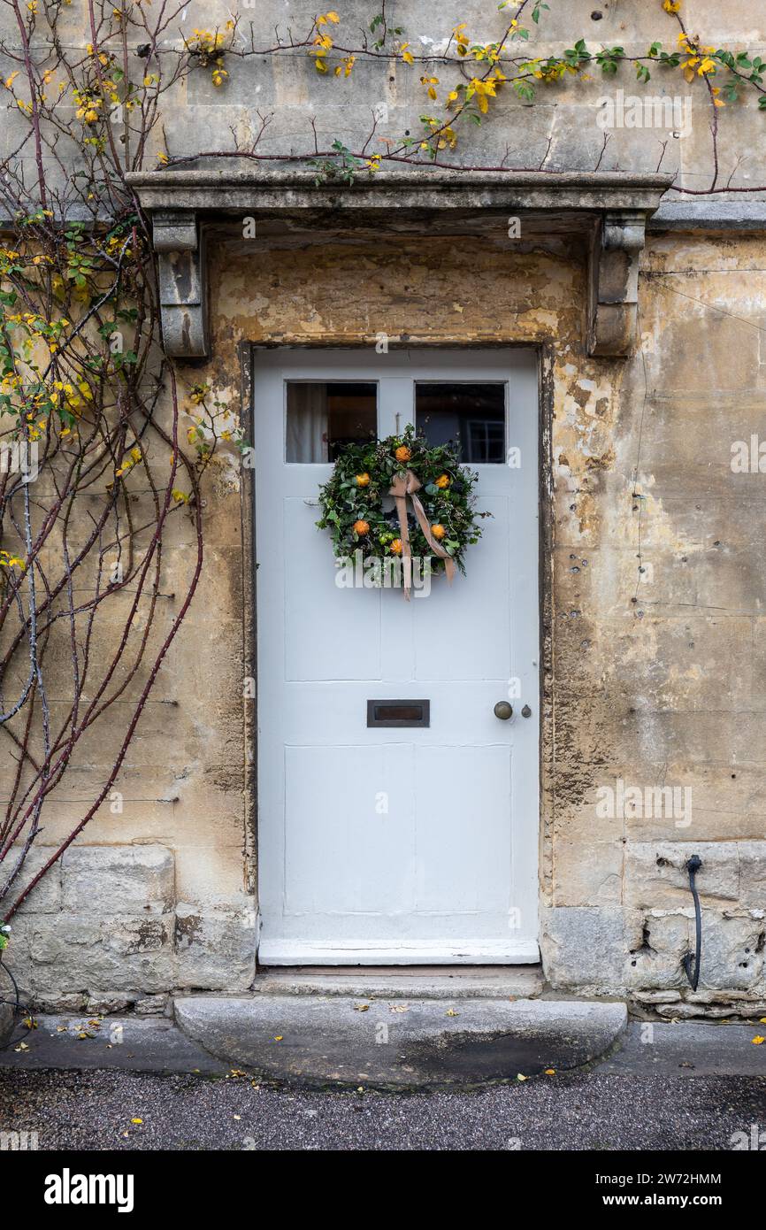 Nahaufnahme einer weißen Eingangstür mit Weihnachtskranz an einem Haus im National Trust Dorf Lacock, Wiltshire, England, Großbritannien Stockfoto