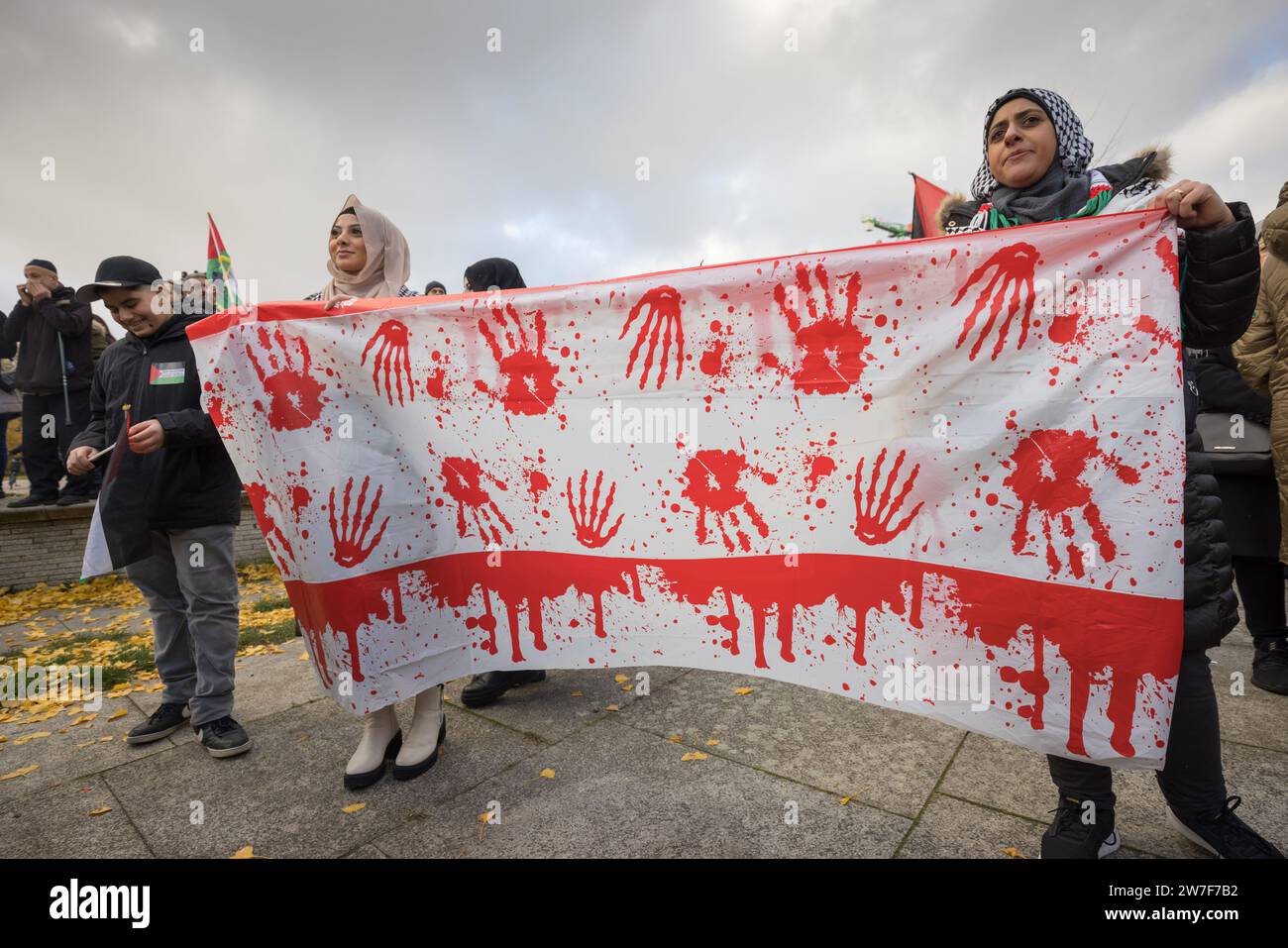 18.11.2023, Deutschland, Berlin, Berlin - große pro-palästinensische Demonstration. Frauen halten ein Banner mit blutigen Händen. Palästinenser und politische Grou Stockfoto