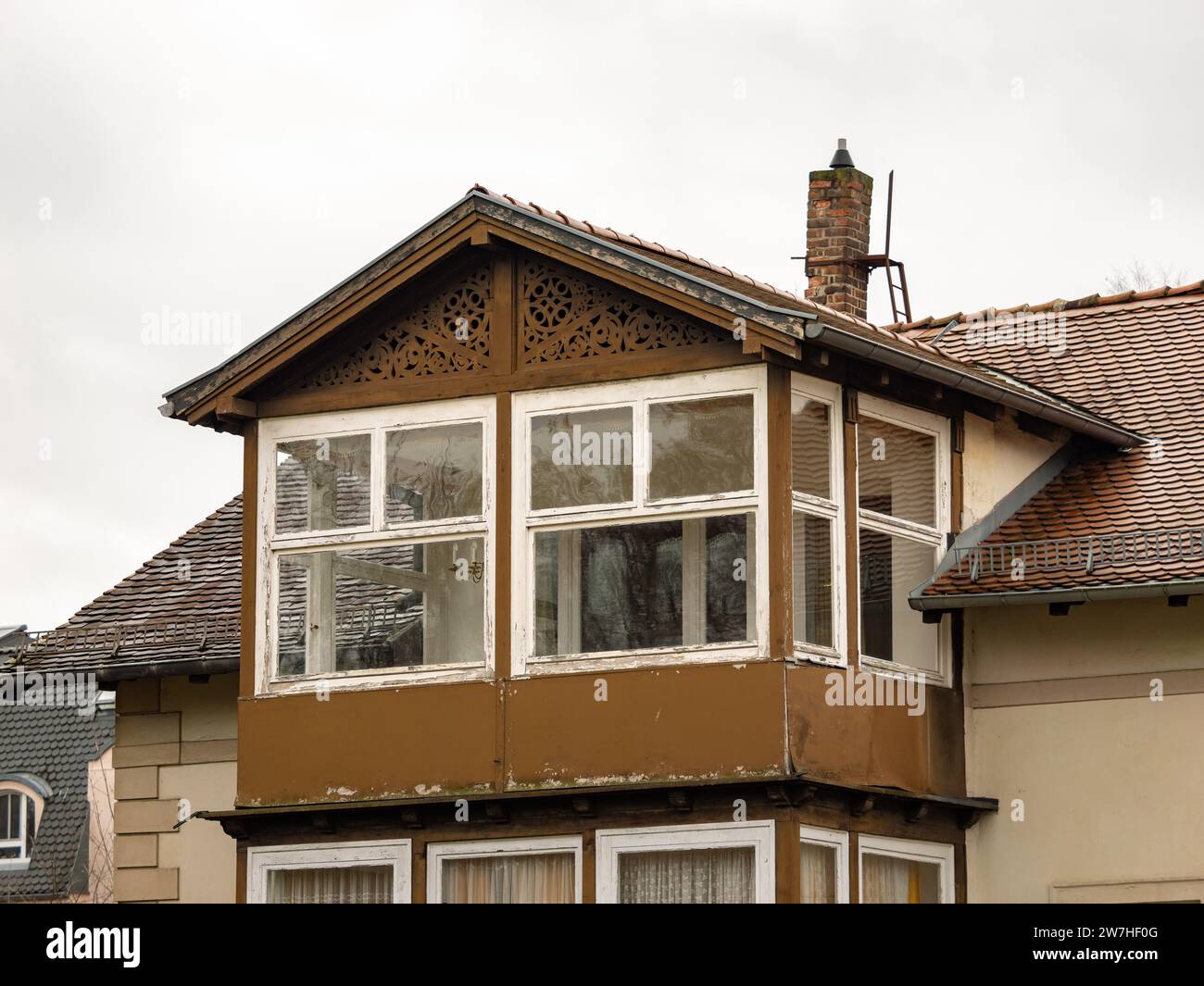 Altes Wohnhaus mit überdachtem Balkon. Die Fenster sind dünn und das Äußere muss renoviert werden. Die Fassade ist verwittert und schmutzig. Stockfoto