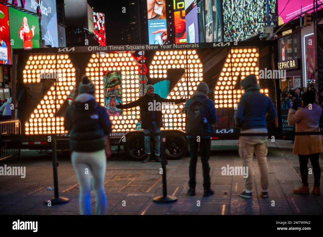 Besucher des Times Square in New York strömen am Mittwoch, den 20. Dezember 2023, zur temporären Ausstellung der Zahlen „2024“. Die „2024“ ist die LED-Anzeige auf dem One Times Square, die am 1. Januar um Mitternacht leuchtet und das neue Jahr einläutet. Die sieben Meter hohen Zahlen bleiben bis Freitag, wenn sie an ihren richtigen Ort gebracht werden. (© Richard B. Levine) Stockfoto