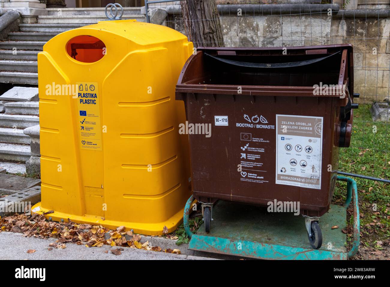 Recyclingbehälter: Gelber Behälter für das Recycling von Kunststoff und grüner Behälter für das Recycling von Bioabfällen Stockfoto