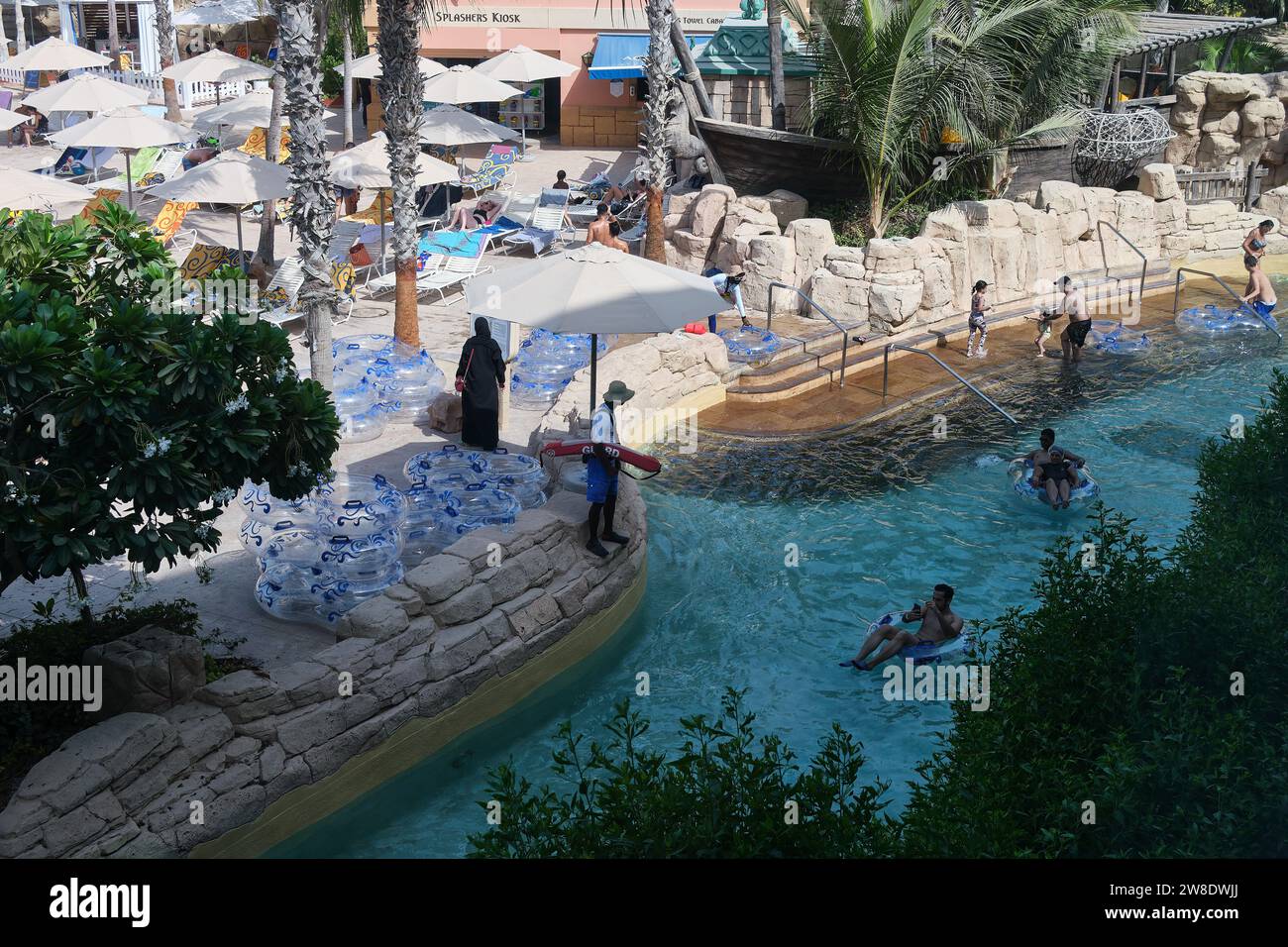 Menschen, die sich auf aufblasbaren Wagen im Pool im Aquaventure Waterpark in Atlantis The Palm, Dubai, Vereinigte Arabische Emirate entspannen Stockfoto