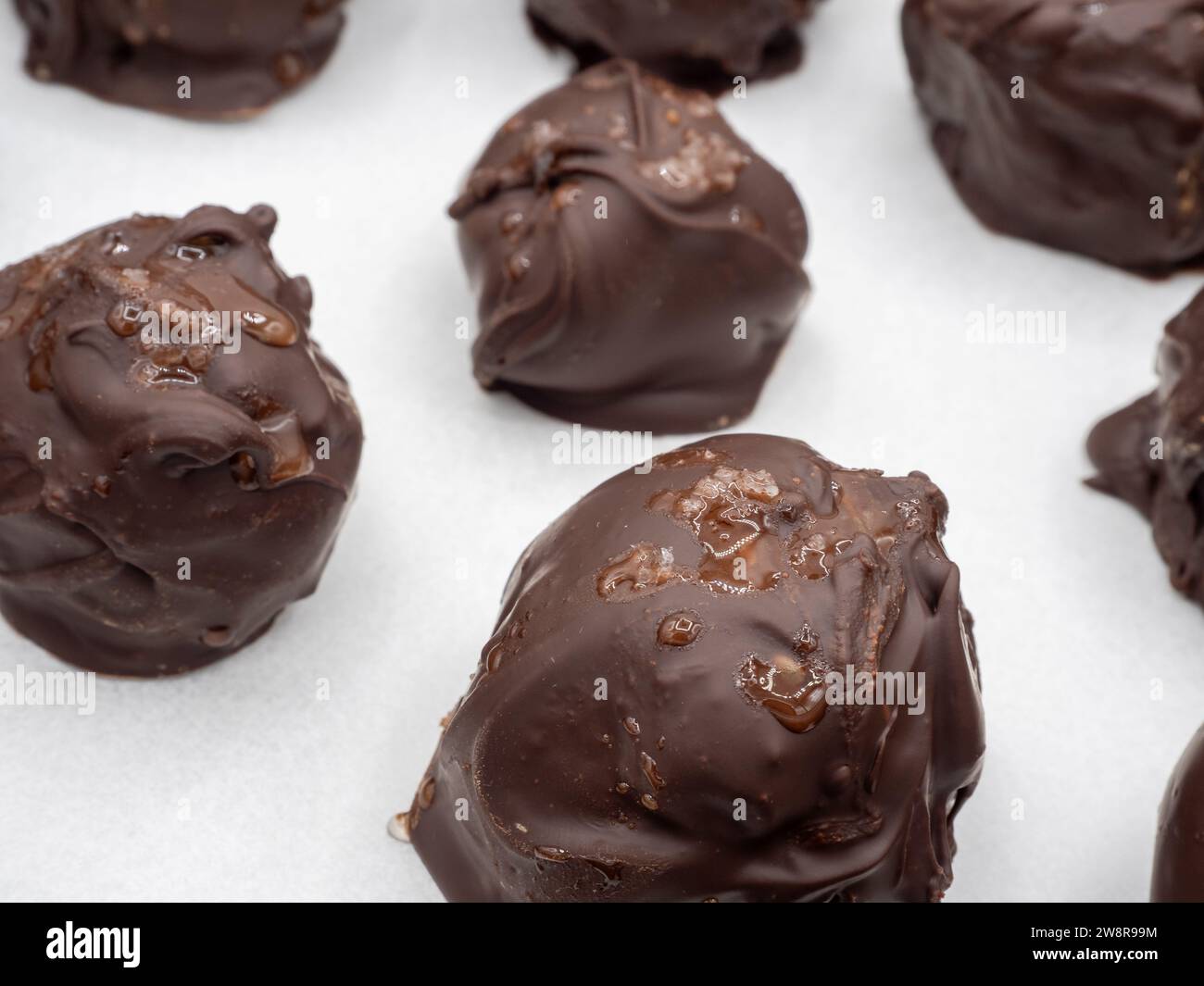 Eine fesselnde Nahaufnahme von handgefertigten schwedischen Lebkuchenbonbons, verziert mit dunkler Schokolade und bestreut mit Meersalzflocken, wunderschön Presente Stockfoto