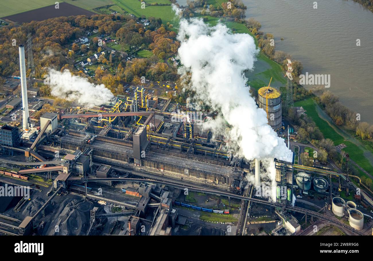 Luftaufnahme, Hüttenwerke Krupp Mannesmann HKM mit Rauchwolken am Rhein, umgeben von herbstlichen Laubbäumen, Hüttenheim, Duisburg, Ruhr Stockfoto