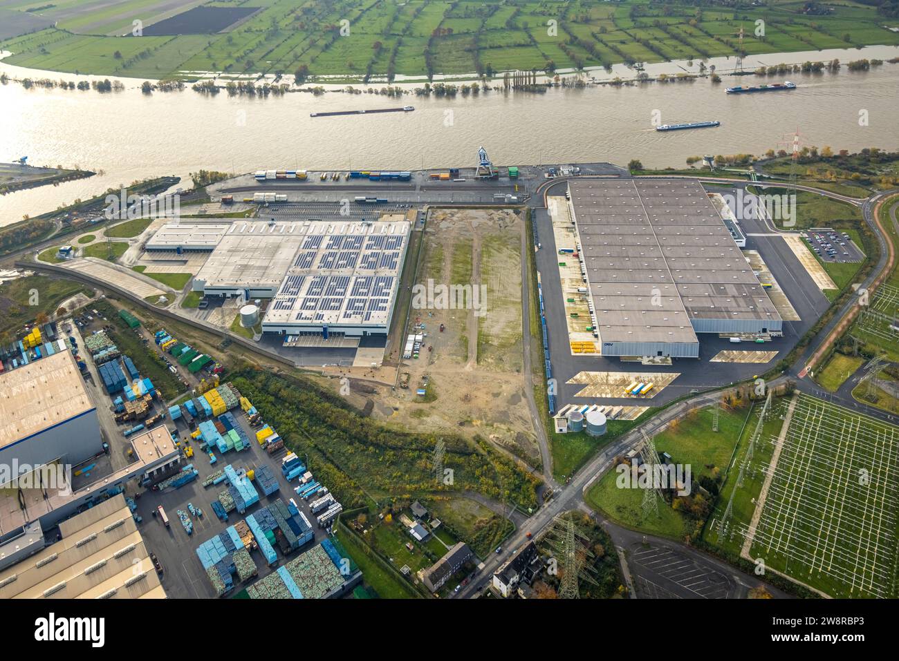 Luftaufnahme, Logport VI (sechs) Industriegebiet Logistikdienstleistungen, Binnenschifffahrt auf dem Rhein mit Hochwasser, umgeben von herbstlicher Deziduo Stockfoto