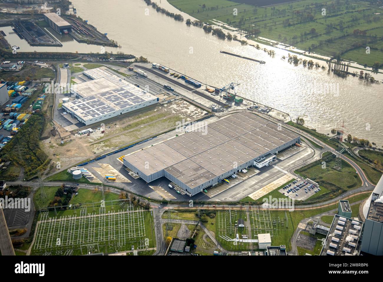 Luftaufnahme, Logport VI (sechs) Industriegebiet Logistikdienstleistungen, Binnenschifffahrt auf dem Rhein mit Hochwasser, umgeben von herbstlicher Deziduo Stockfoto