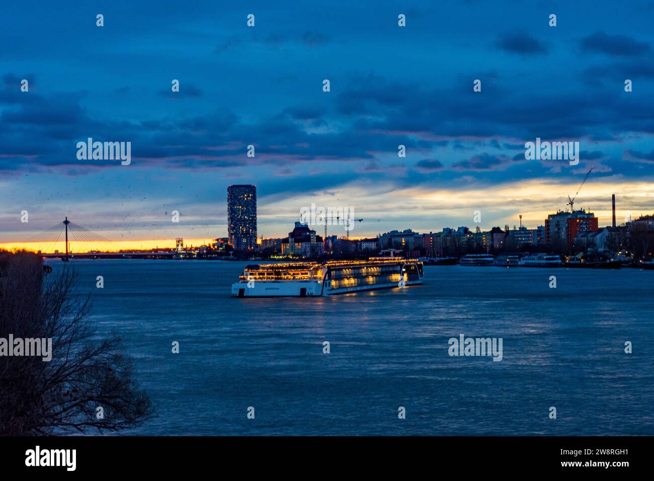 Wien: Sonnenaufgang an der Donau (Donau), Kreuzfahrtschiff in Weihnachtsdekoration, Seilbrücke Donaustadtbrücke, Marina Tower in 02. Leopol Stockfoto