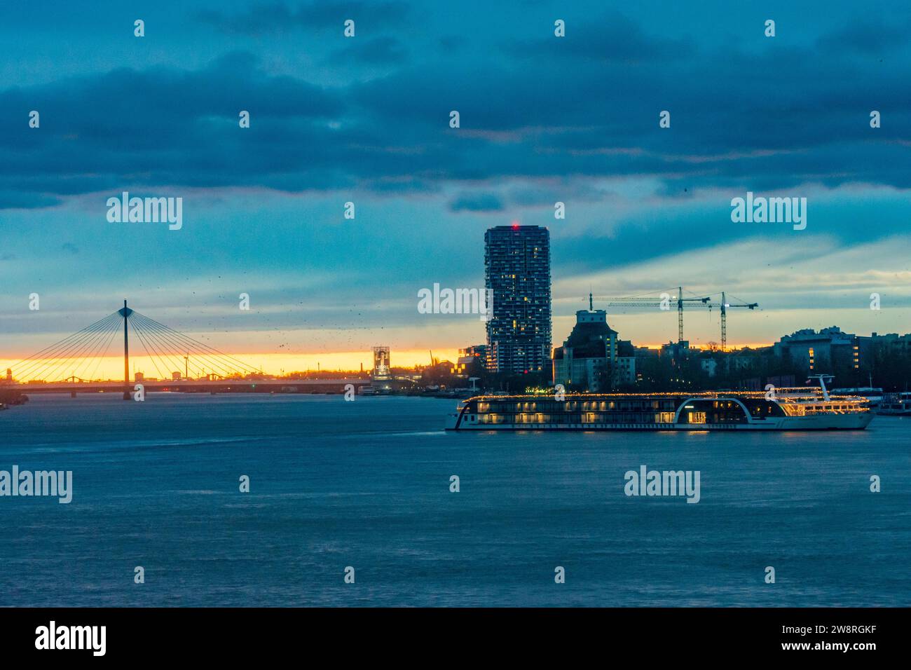 Wien: Sonnenaufgang an der Donau (Donau), Kreuzfahrtschiff in Weihnachtsdekoration, Seilbrücke Donaustadtbrücke, Marina Tower in 02. Leopol Stockfoto