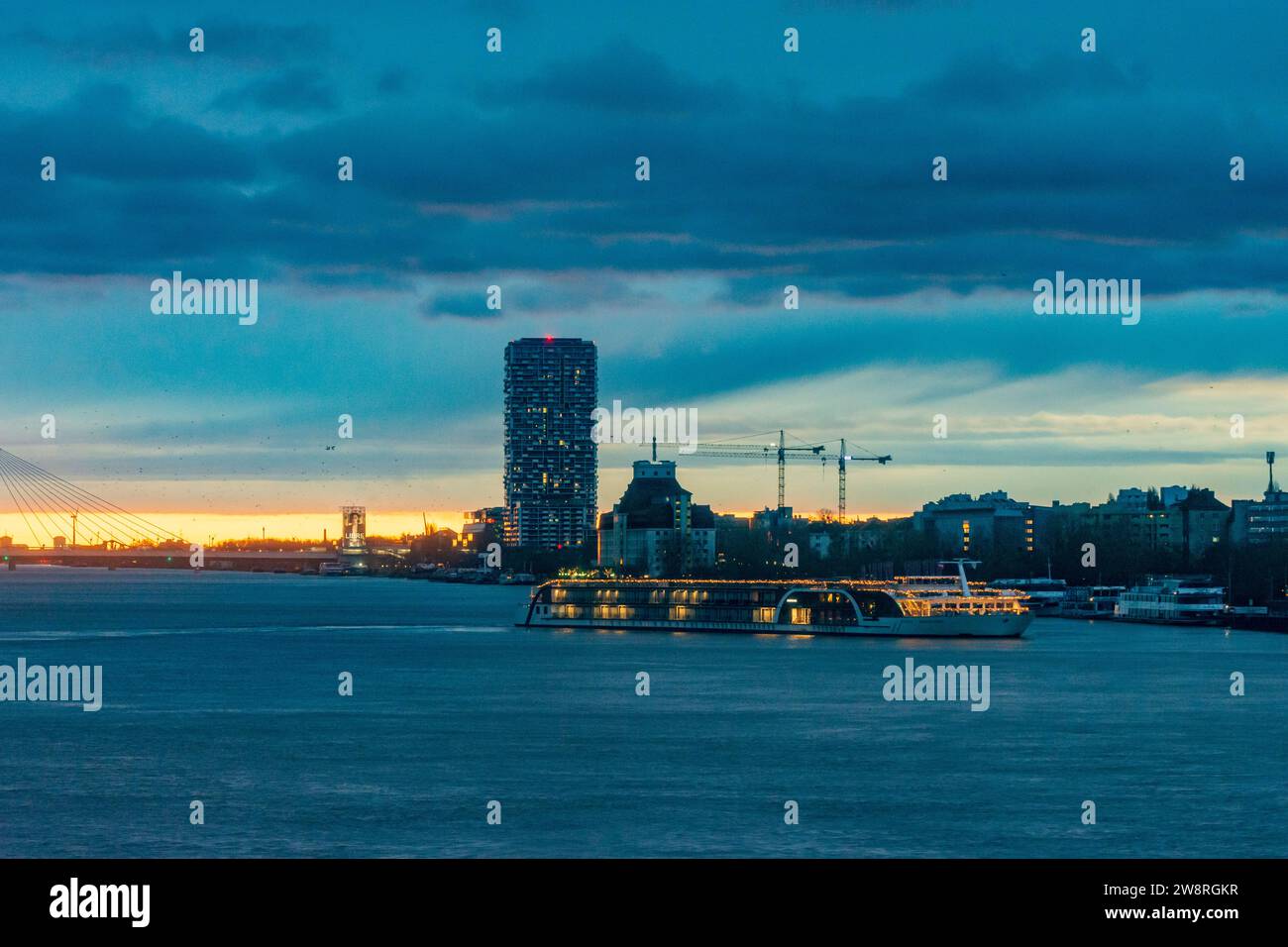 Wien: Sonnenaufgang an der Donau (Donau), Kreuzfahrtschiff in Weihnachtsdekoration, Seilbrücke Donaustadtbrücke, Marina Tower in 02. Leopol Stockfoto
