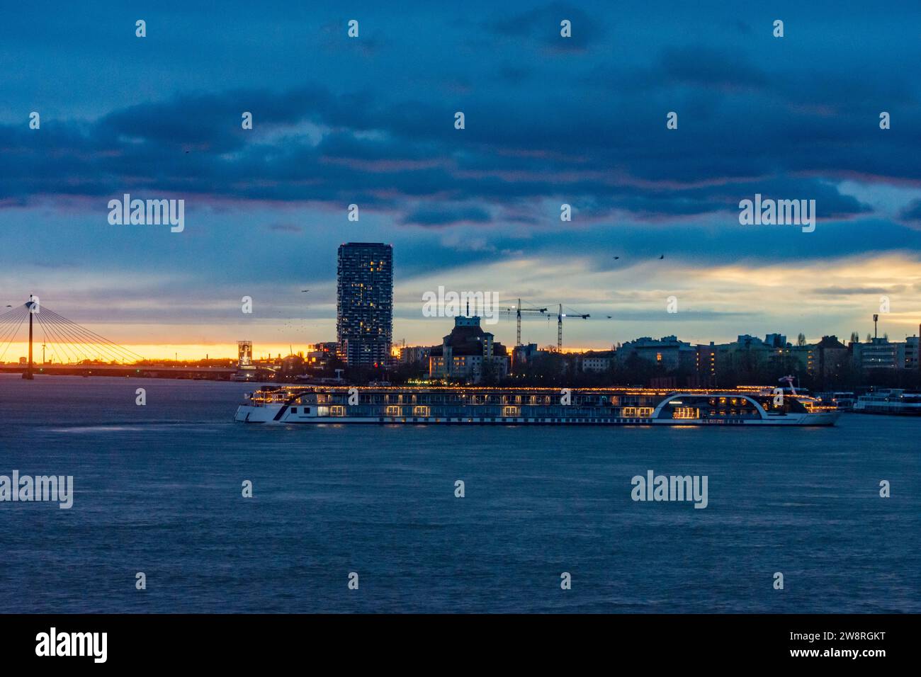 Wien: Sonnenaufgang an der Donau (Donau), Kreuzfahrtschiff in Weihnachtsdekoration, Seilbrücke Donaustadtbrücke, Marina Tower in 02. Leopol Stockfoto