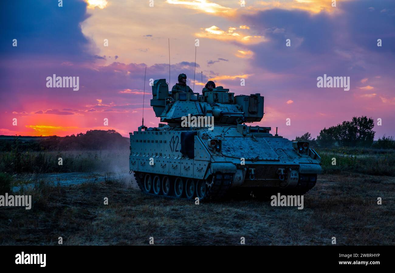 Soldaten der US-Armee, die dem 1. Bataillon, 16. Infanterieregiment, 1. Panzerbrigade Combat Team, 1. Infanteriedivision, zugewiesen wurden, stationieren ihr Bradley-Kampffahrzeug während der Dämmerung, um sich auf eine nächtliche Trainingsoperation in Fort Riley, Kansas, vorzubereiten, am 21. September 2023. Soldaten nahmen an einer nächtlichen Trainingsübung Teil, bei der sie ihre Verwendung von Infrarotsignalen und Teambewegungen unter dem Schutz der Dunkelheit testen. (Foto der US-Armee von SPC. Kenneth Barnet) Stockfoto