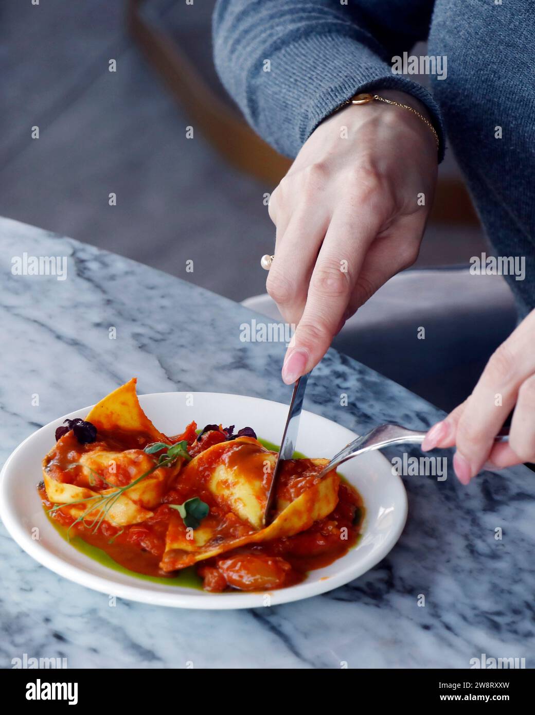 italienisches Essen Nudelgericht Hummer gefüllte Ravioli mit Safrantomatensauce in Nahaufnahme auf einem Esstisch Stockfoto