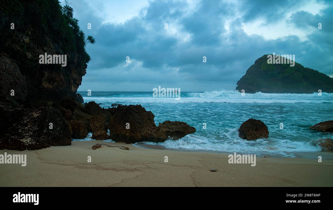 Goa Cina Beach, Malang, Indonesien am Morgen. Die Atmosphäre von stürzenden Wellen mit steilen Felsen Stockfoto