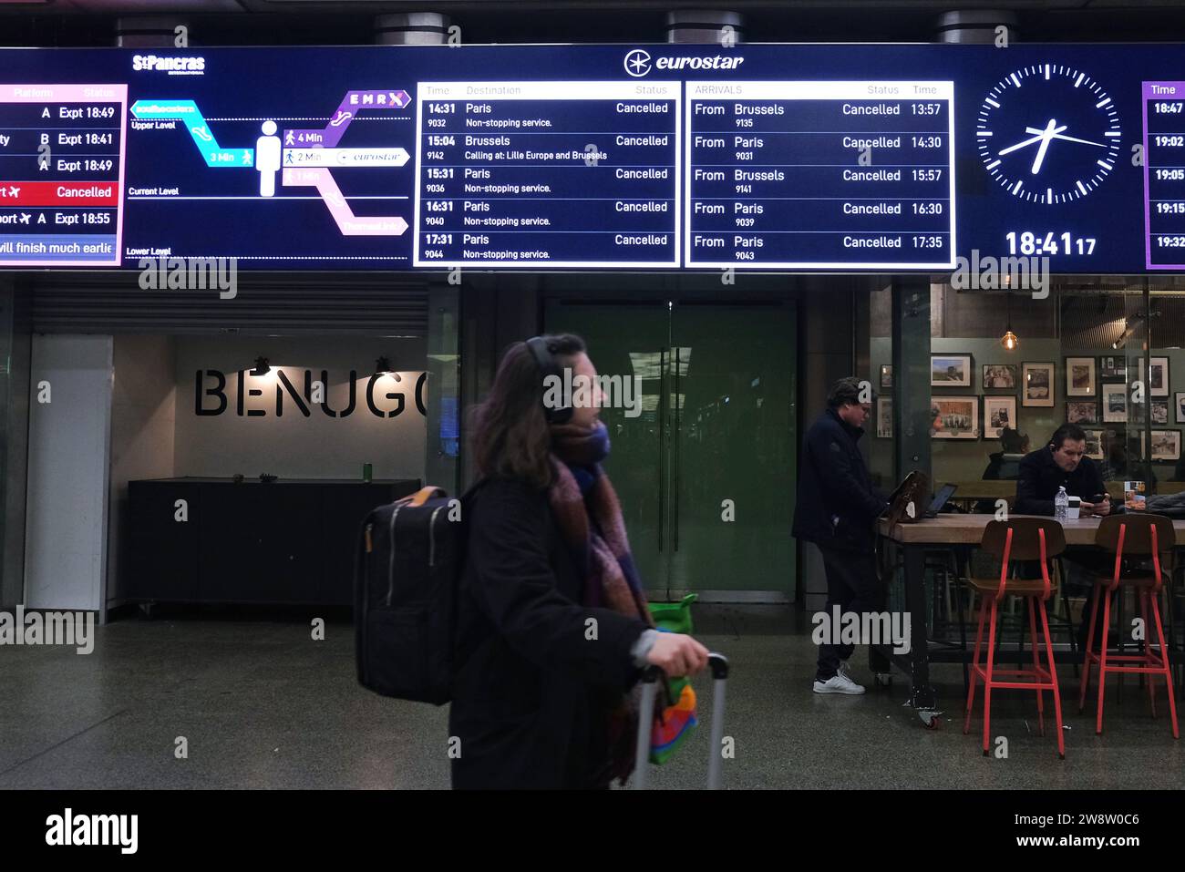 London, Großbritannien. Dezember 2023. Ein Reisender passiert eine Eurostar-Informationstafel. Am Eurostar-Terminal in St. Pancras, wo ein früherer Streik von Mittag bis zum frühen Abend stattfand, als französische Arbeiter einen unerwarteten Ausstieg inszenierten und Dutzende von Zügen ausfielen. Es wird nicht erwartet, dass der Service bis Freitag fortgesetzt wird, was Tausende von Passagieren betrifft. Quelle: Eleventh Photography/Alamy Live News Stockfoto