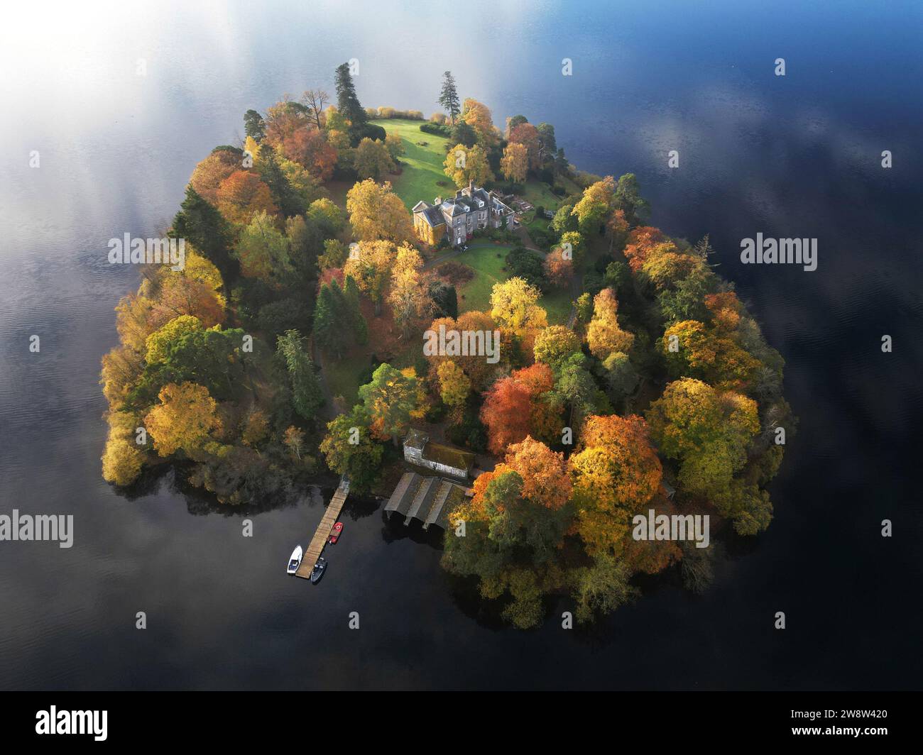 PA REVIEW OF THE YEAR 2023 Aktenfoto vom 05/11/23 - Herbstfarben auf den Bäumen auf Derwent Island auf Derwentwater im Lake District. Ausgabedatum: Donnerstag, 21. Dezember 2023. Stockfoto