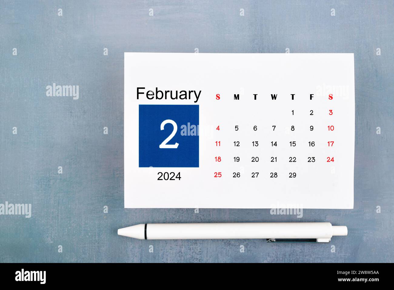 Februar-Kalender 2024 Seite mit Stift auf blauem hölzernem Hintergrund. Stockfoto
