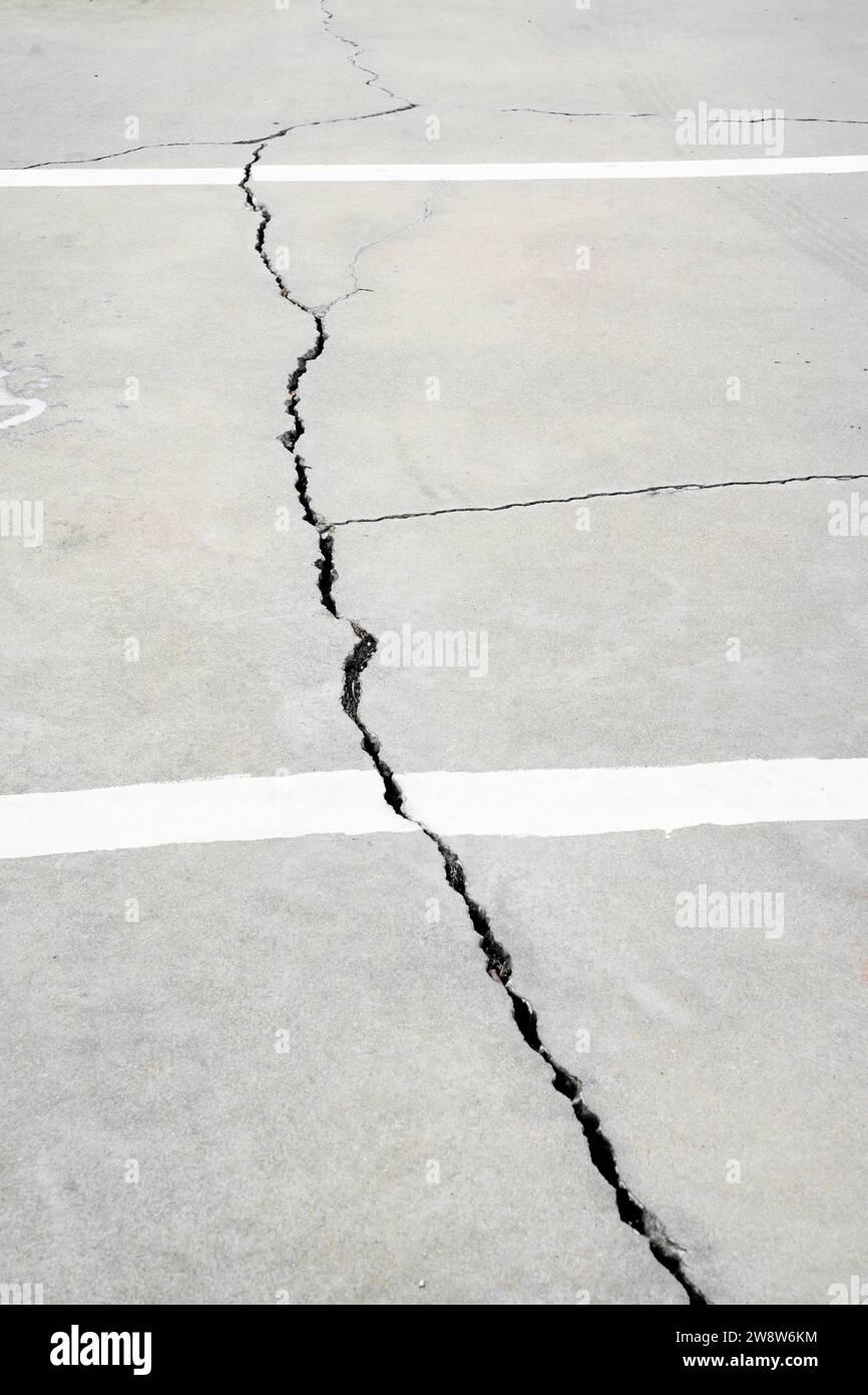 Ein Riss läuft über einen Zementboden auf der Straße. Stockfoto