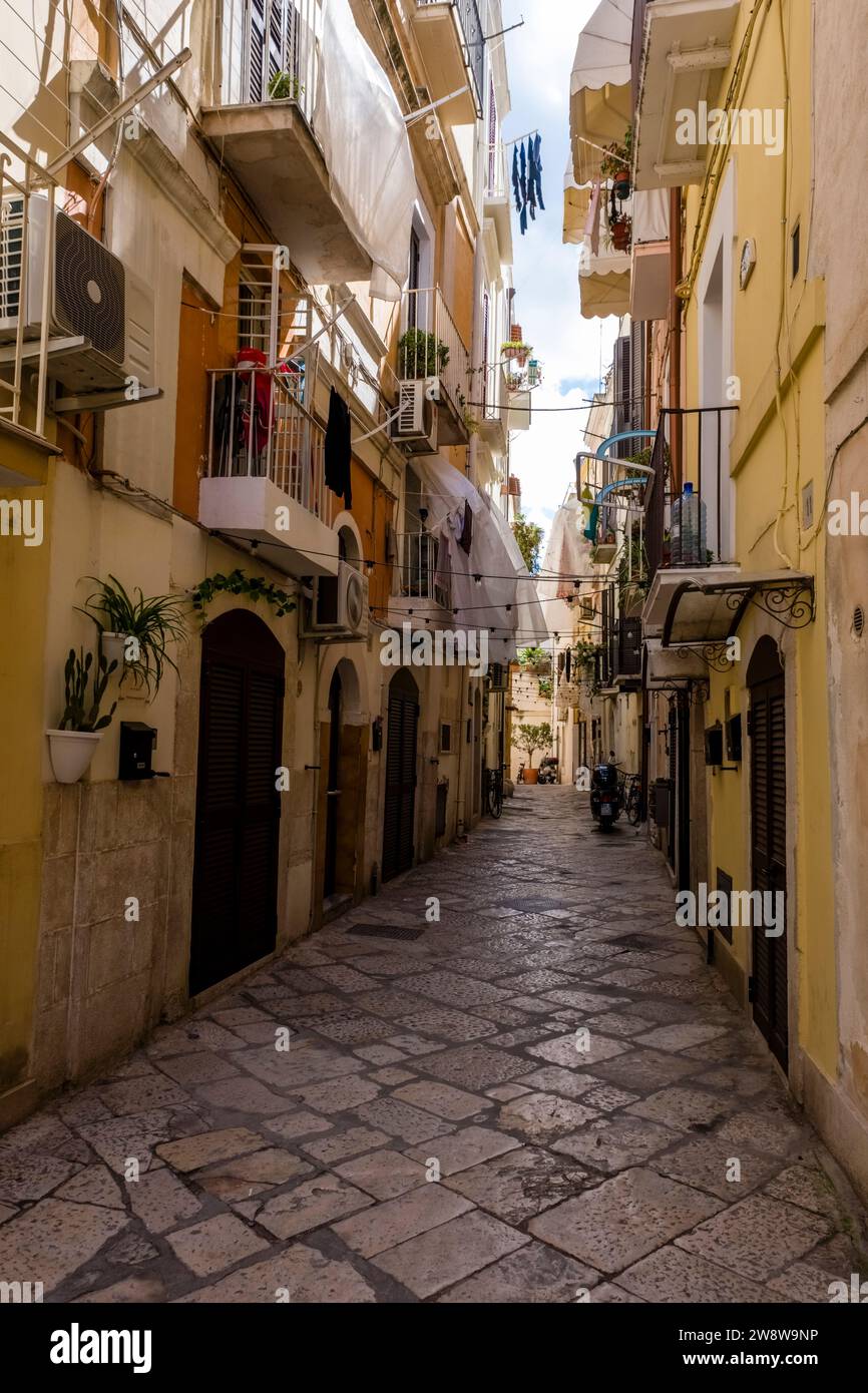 Straßenszene mit einer kleinen Straße zwischen Häusern, Balkonen und Wäschetrocknung an Wäscheleinen. Stockfoto