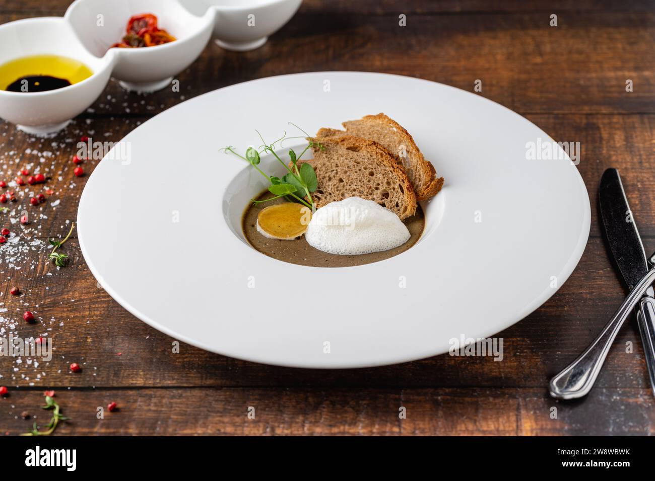 Crostini Fegatini auf weißem Porzellanteller auf Holztisch Stockfoto