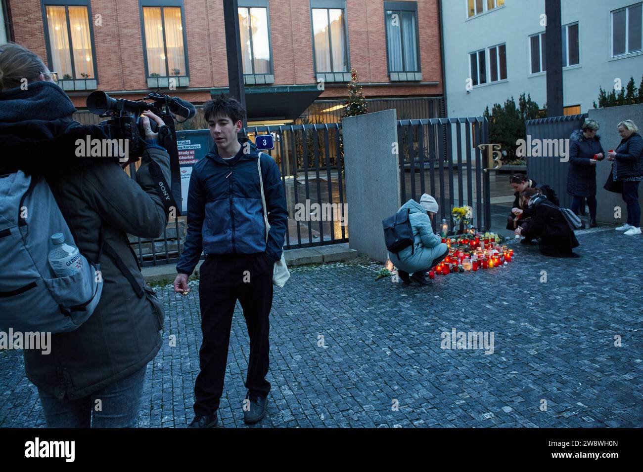 Studenten und andere Leute zünden Kerzen aus dem Hauptquartier der Charles University an. Angriff innerhalb der Charles University durch einen Studenten, der rechtmäßig besessene halbautomatische Schießpistolen in der Tasche zur Universität brachte, 14 Studenten tötete und weitere 25 verletzte. 22.12.2023 Prag, Tschechische Republik. Quelle: Martin Hladik/AFLO/Alamy Live News Stockfoto