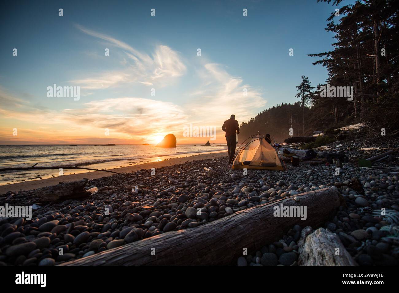 Silhouette eines Mannes, der am Strand campt. Stockfoto