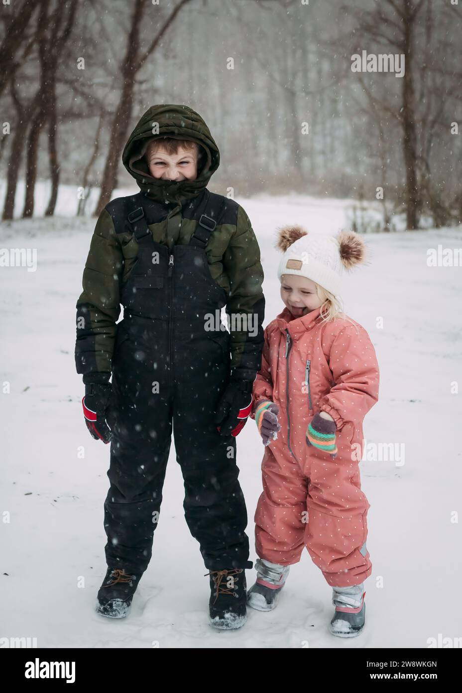 Kinder tragen im Winter Schneeanzüge Stockfoto