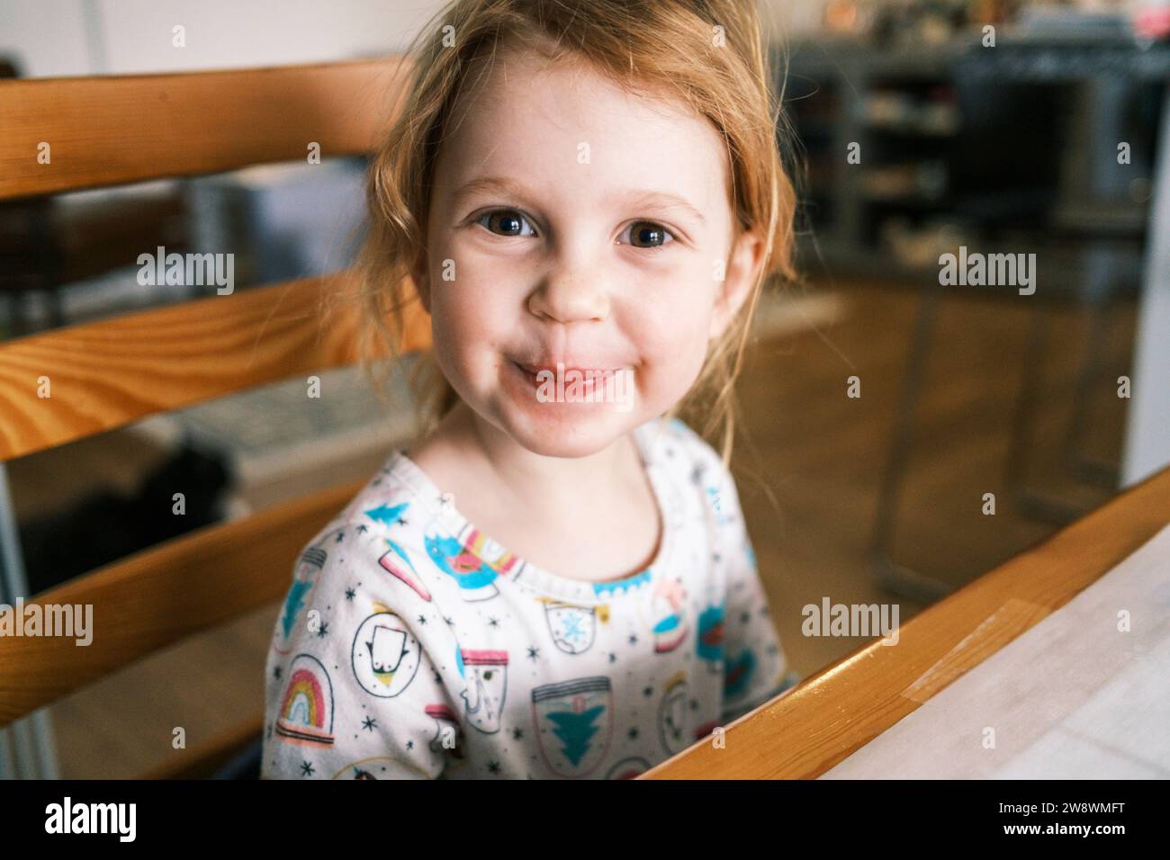 Lächelndes Mädchen mit einem fröhlichen Ausdruck, der in die Kamera schaut Stockfoto