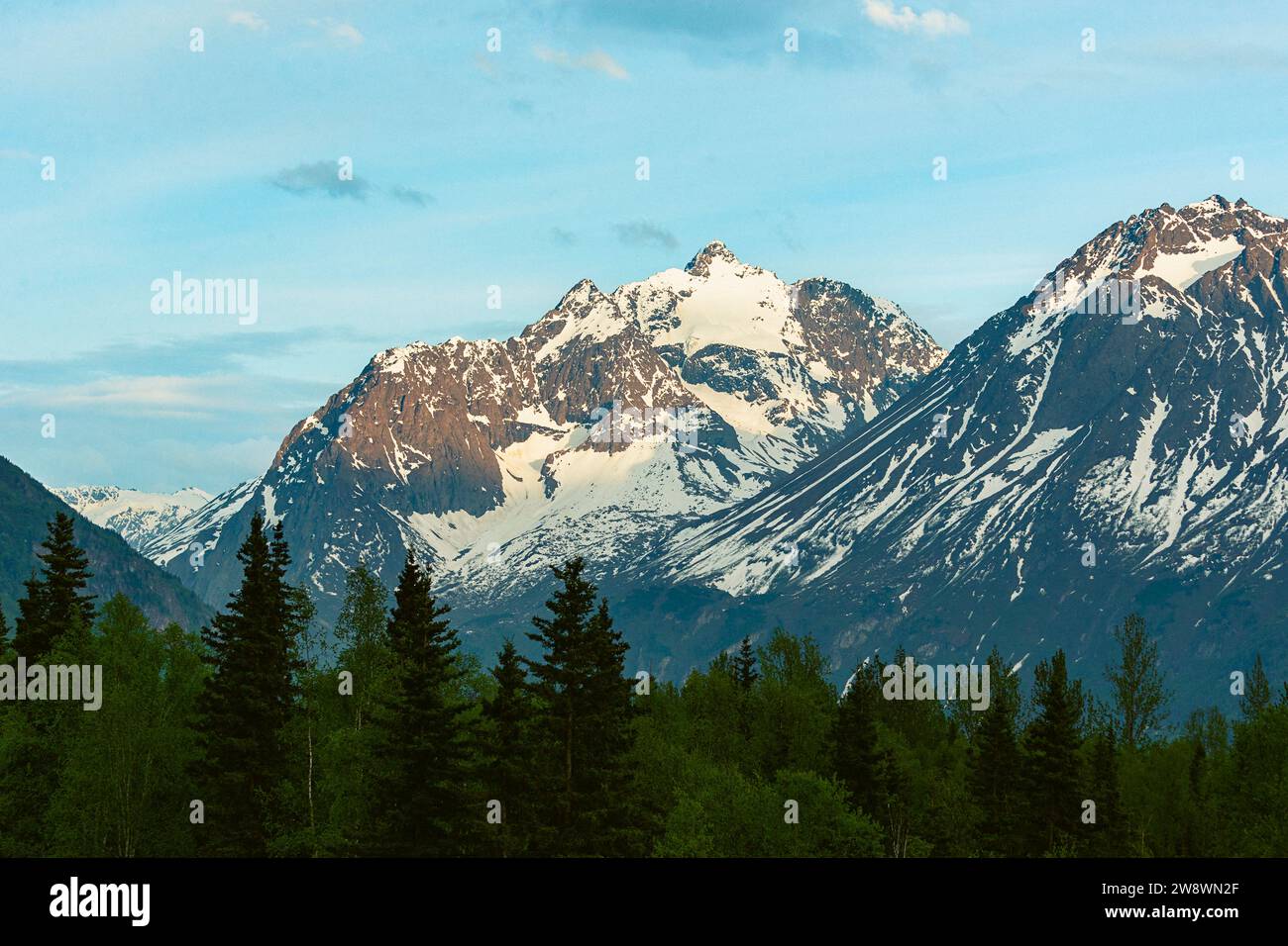 Zerklüftete Berggipfel werden von der untergehenden Sonne in Alaska beleuchtet Stockfoto