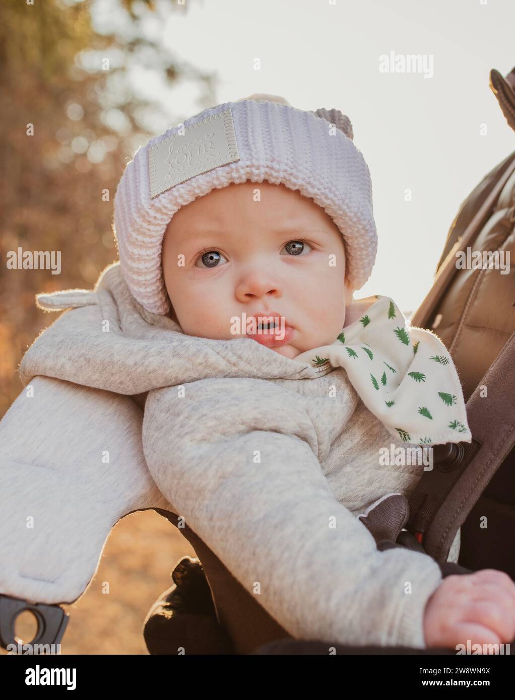 Baby in Wintermütze draußen im warmen Licht Stockfoto