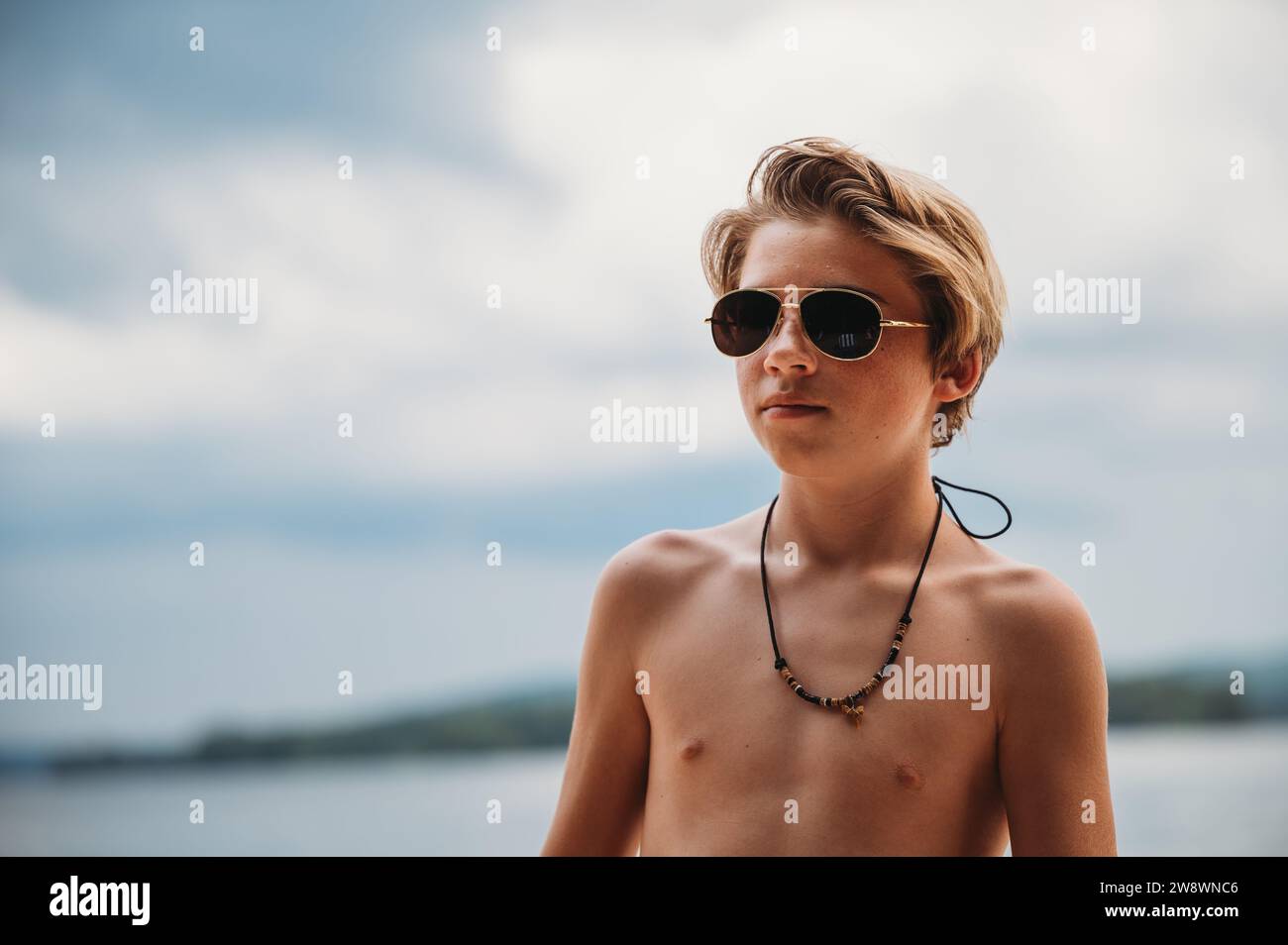 Nahaufnahme von Tween Boy mit Sonnenbrille ohne Hemdhalskette Stockfoto