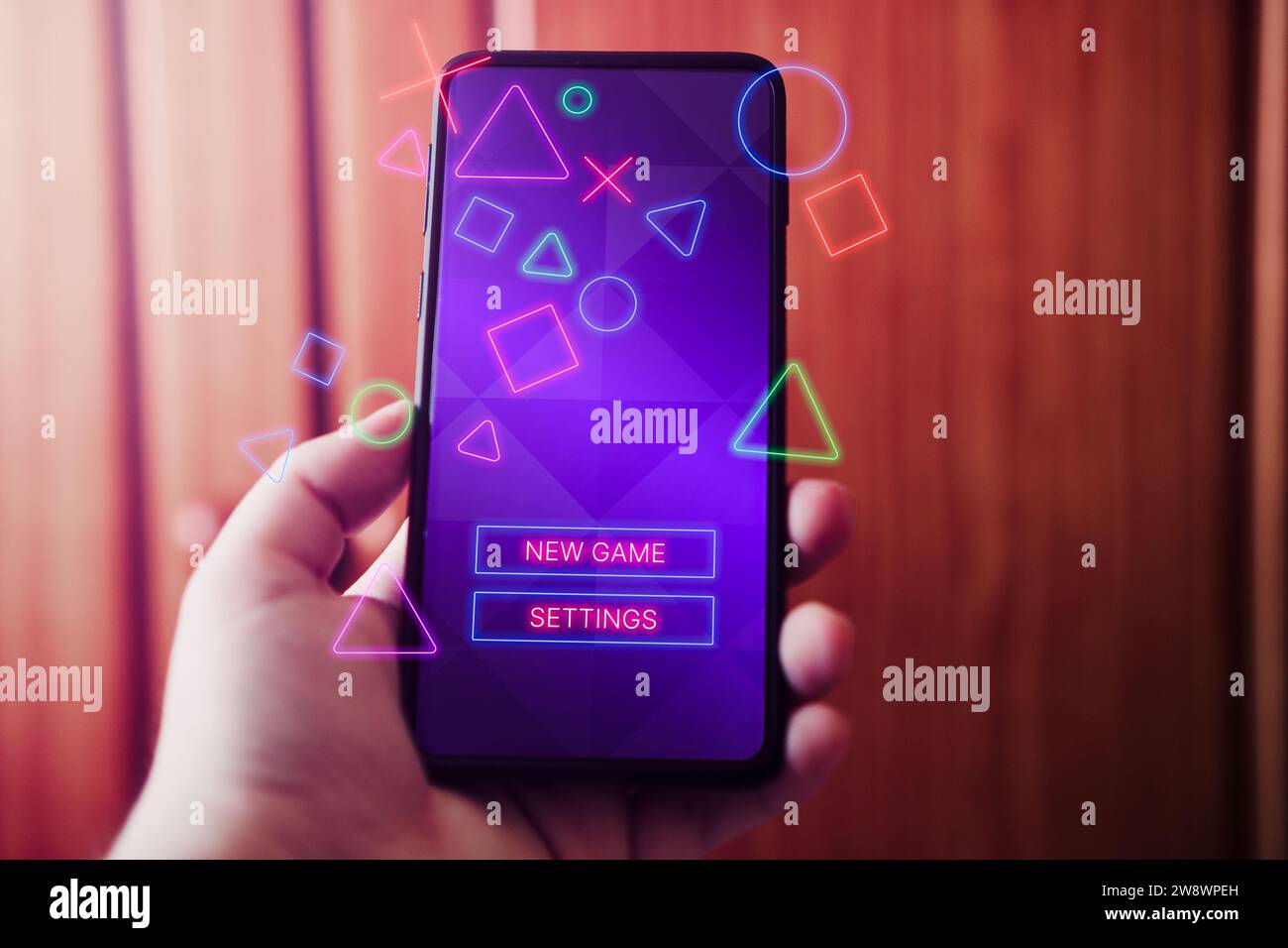 Weibliche Hand zeigt Smartphone mit Spielschnittstelle auf dem Bildschirm. Online-Konzept wird mit leerem Platz für Text wiedergegeben. Online-Unterhaltung. Stockfoto
