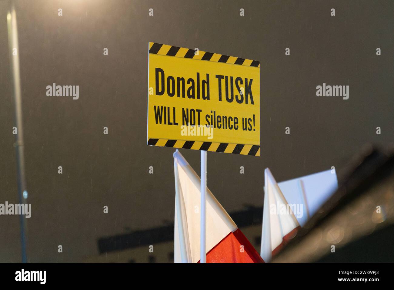 Ein Demonstrant hält ein Banner mit der Inschrift: Donald Tusk wird uns nicht zum Schweigen bringen während einer Kundgebung vor dem Fernsehstudio des polnischen Fernsehsenders in Warschau am 21. Dezember 2023. Dutzende versammelten sich vor dem staatseigenen Fernsehstudio, um gegen die Schritte der neu gewählten pro-europäischen Koalition zu protestieren, die Integrität und Objektivität in den öffentlichen Medien wiederherzustellen. Demonstration zur Verteidigung der TVP. 2023/12/21 Copyright: XMarekxAntonixIwanczukx MAI08339-Enhanced-NR Stockfoto