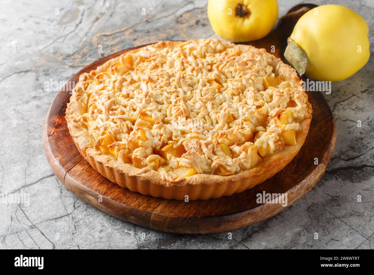 Crumble Tarte köstliche Kombination aus süßer, reichhaltiger Quitte mit Streusel Closeup auf dem Holzbrett auf dem Tisch. Horizontal Stockfoto