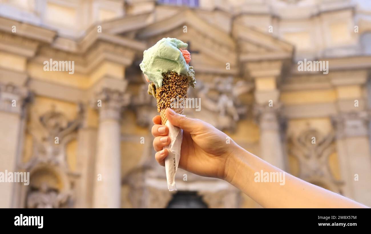 Italienisches Gericht - italienisches Eismais in der Hand - italienisches Eis in der Hand der Frau. Die Frauenhand hält italienische Eiscreme Stockfoto