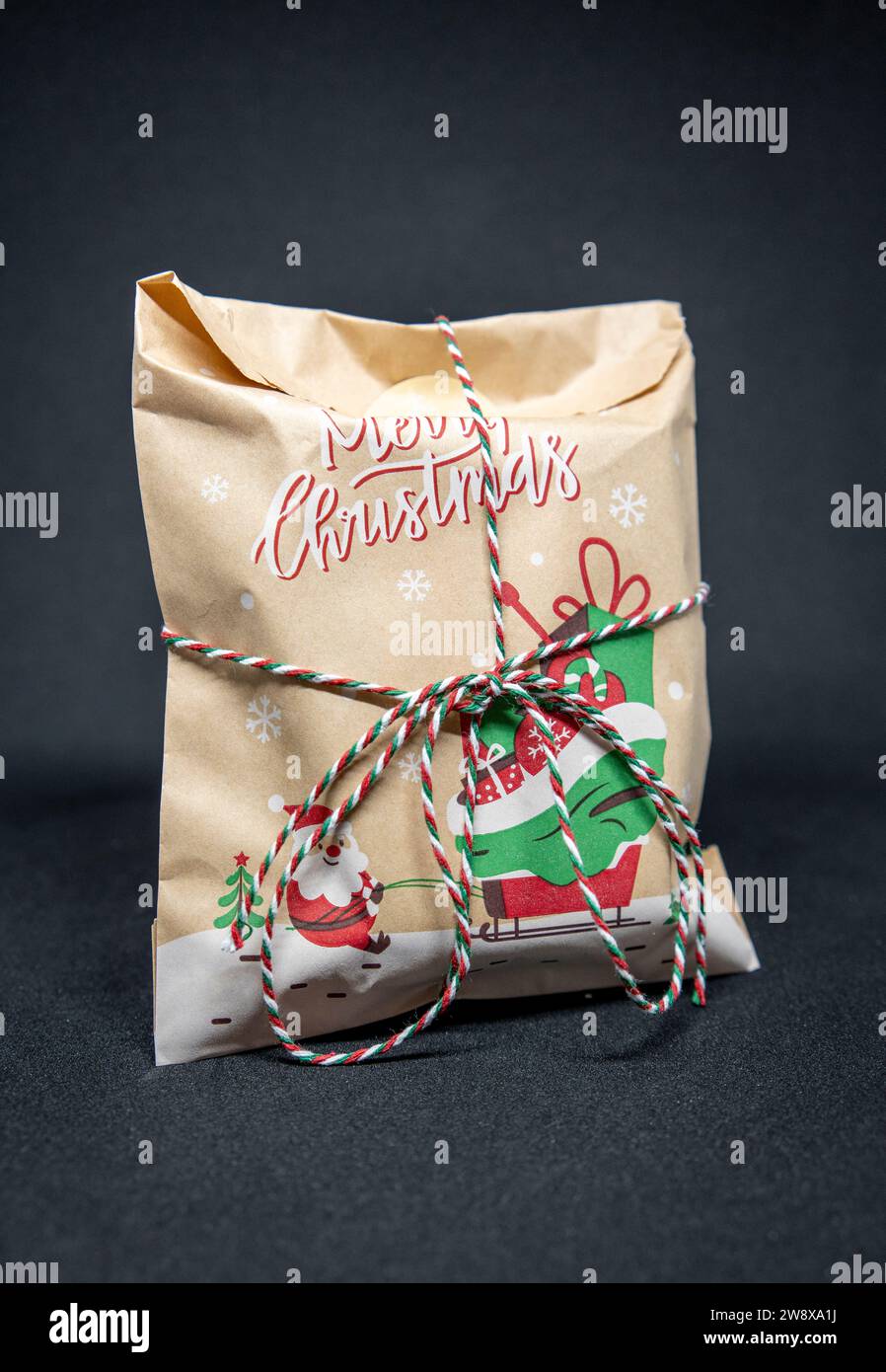 Weihnachtsgeschenk in Nahaufnahme eingewickelt und gebunden Stockfoto