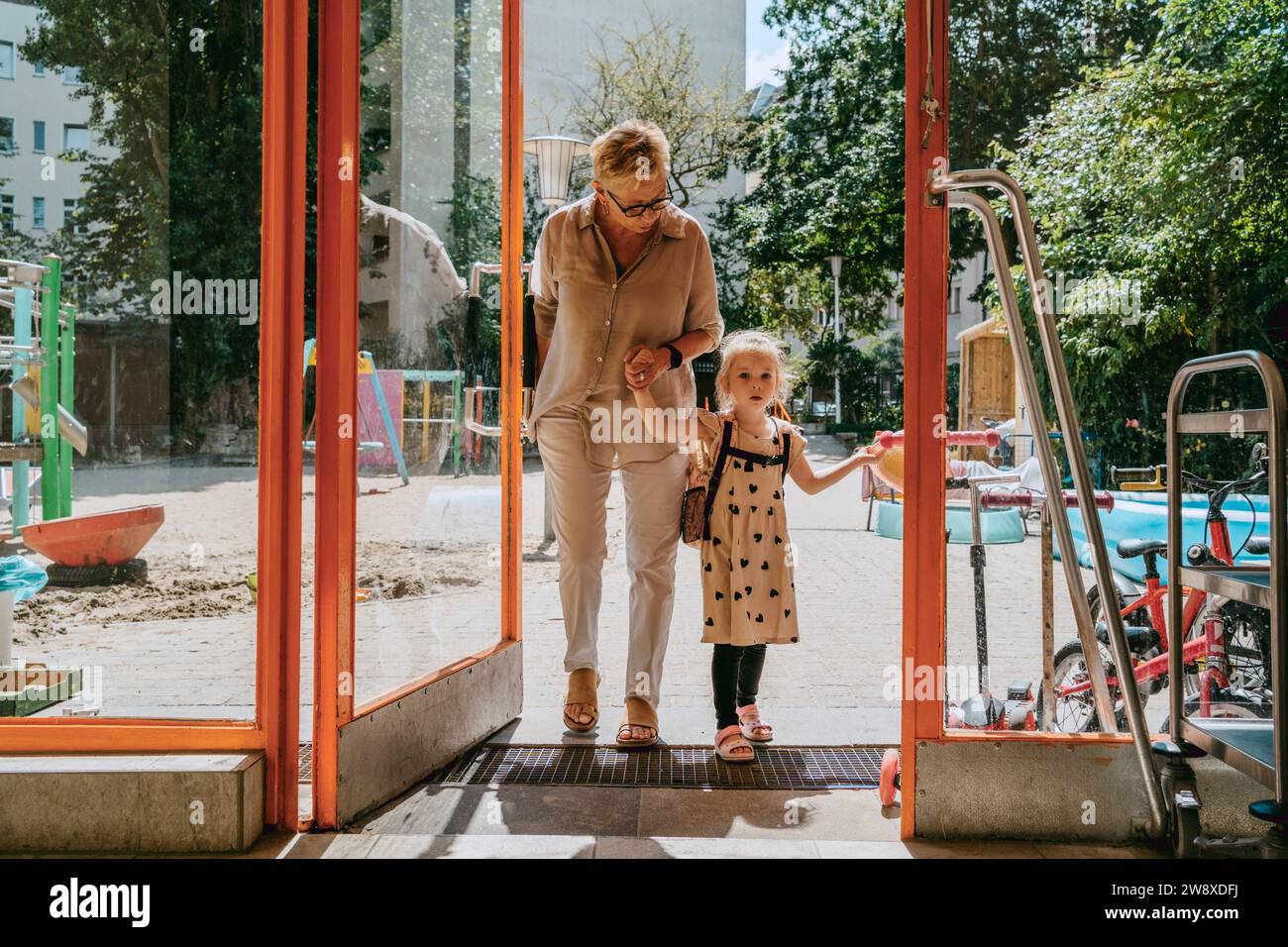 Enkelin mit Großmutter im Kindergarten Stockfoto