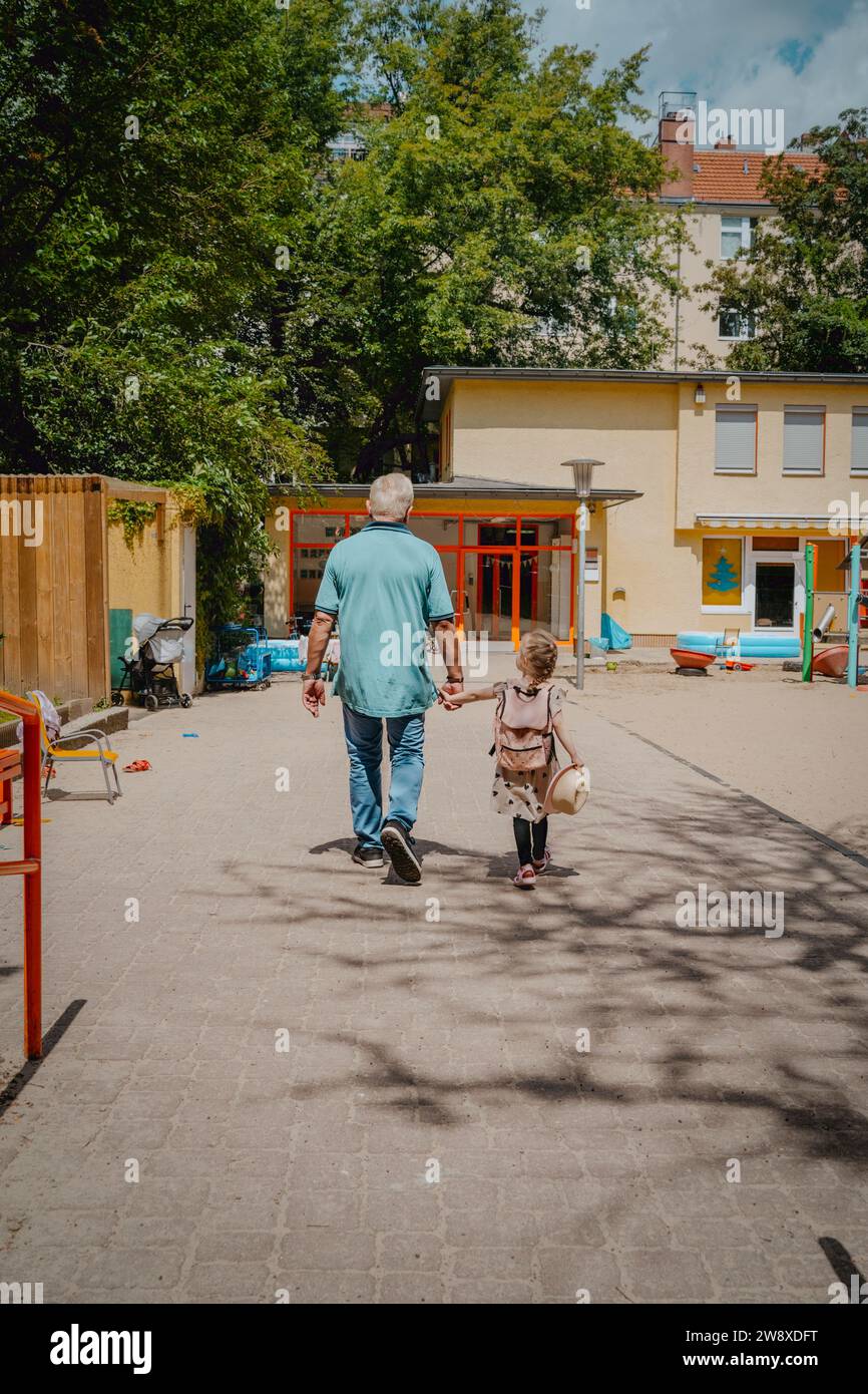Großvater mit Enkelin auf Fußweg zum Kindergarten Stockfoto