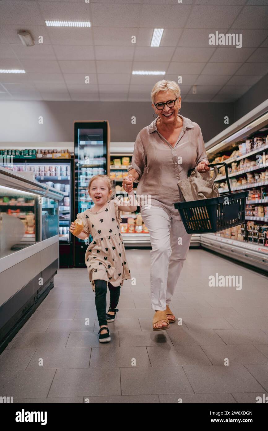 Glückliche Seniorin genießt mit Enkelin beim Einkaufen im Laden Stockfoto