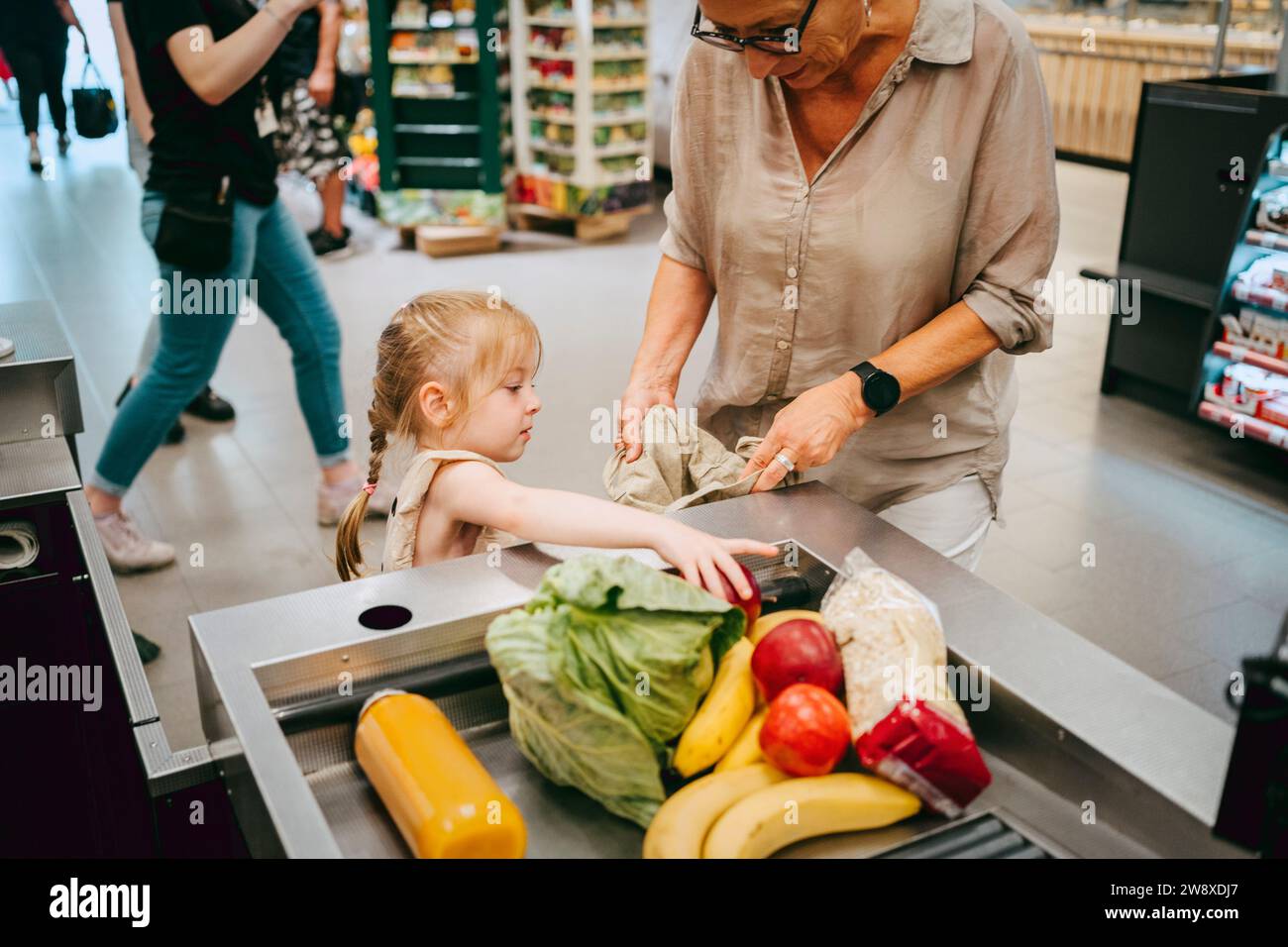 Das Mädchen hilft Großmutter beim Einkaufen im Supermarkt Stockfoto