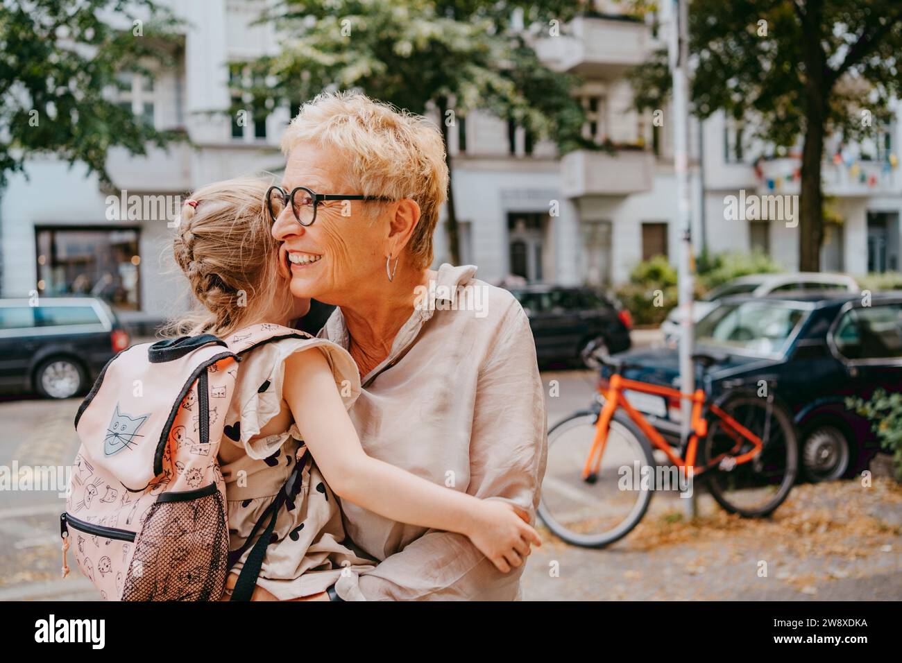 Enkelin umschließt Großmutter auf der Straße Stockfoto