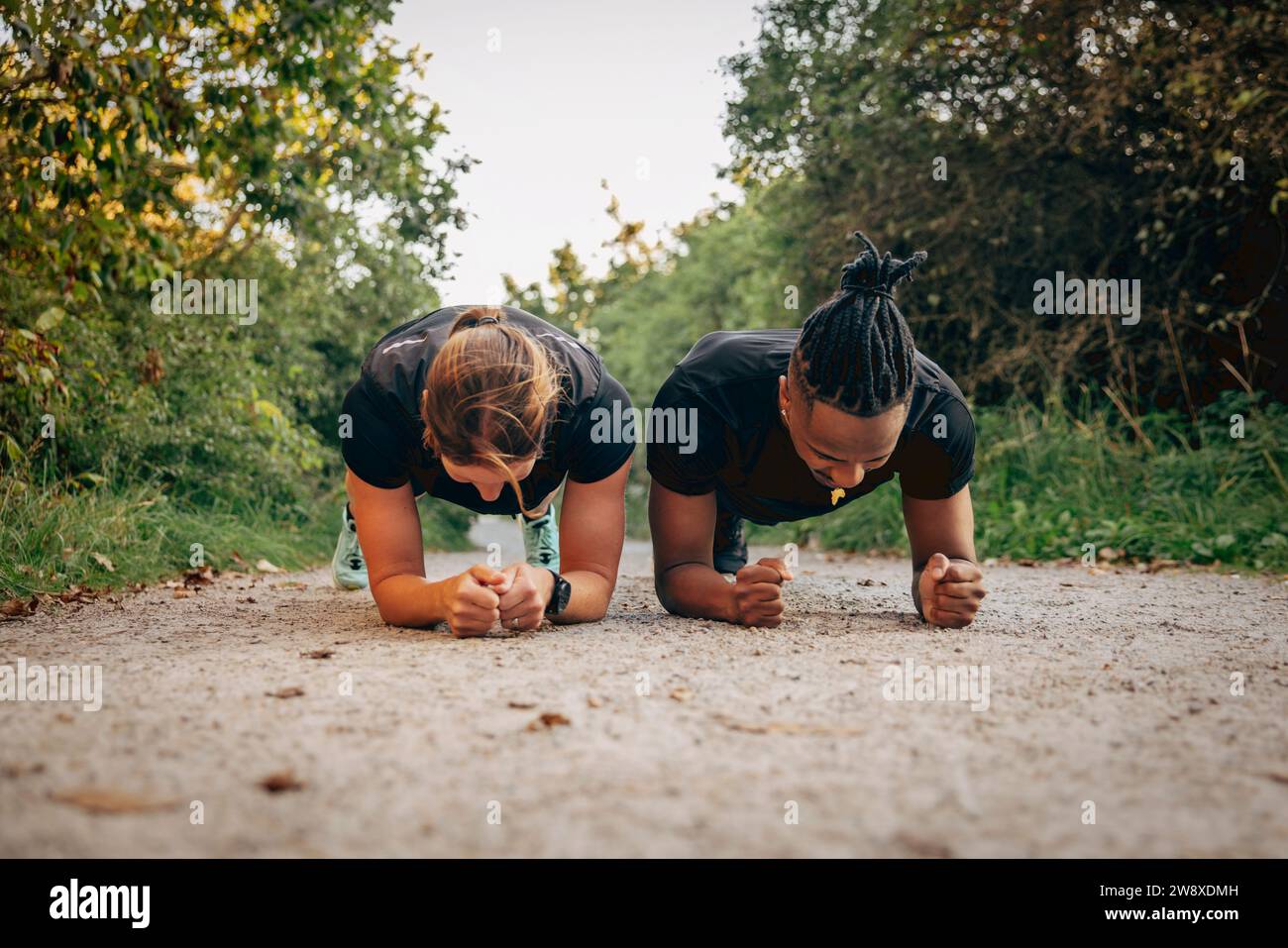 Entschlossener Mann und Frau, die Plank auf dem Fußweg machen Stockfoto