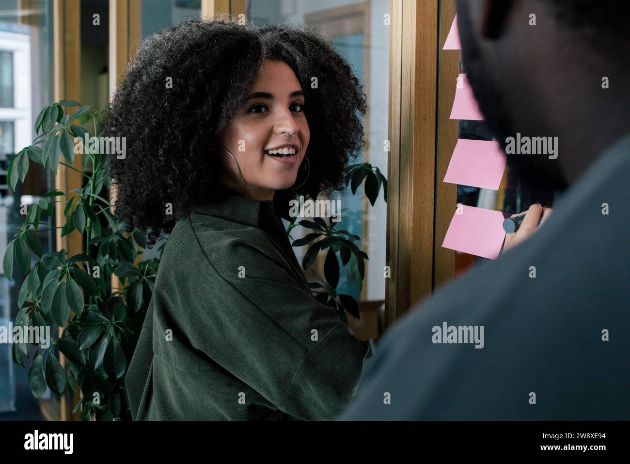 Lächelnde Geschäftsfrau, die sich mit einem männlichen Kollegen im Büro trifft Stockfoto