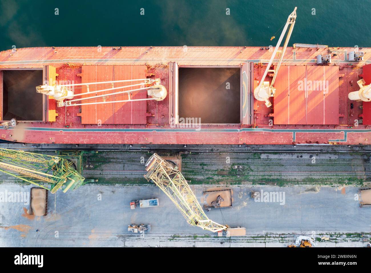 Draufsicht von einer Drohne eines großen Schiffes, das Getreide für den Export lädt. Wassertransport Stockfoto