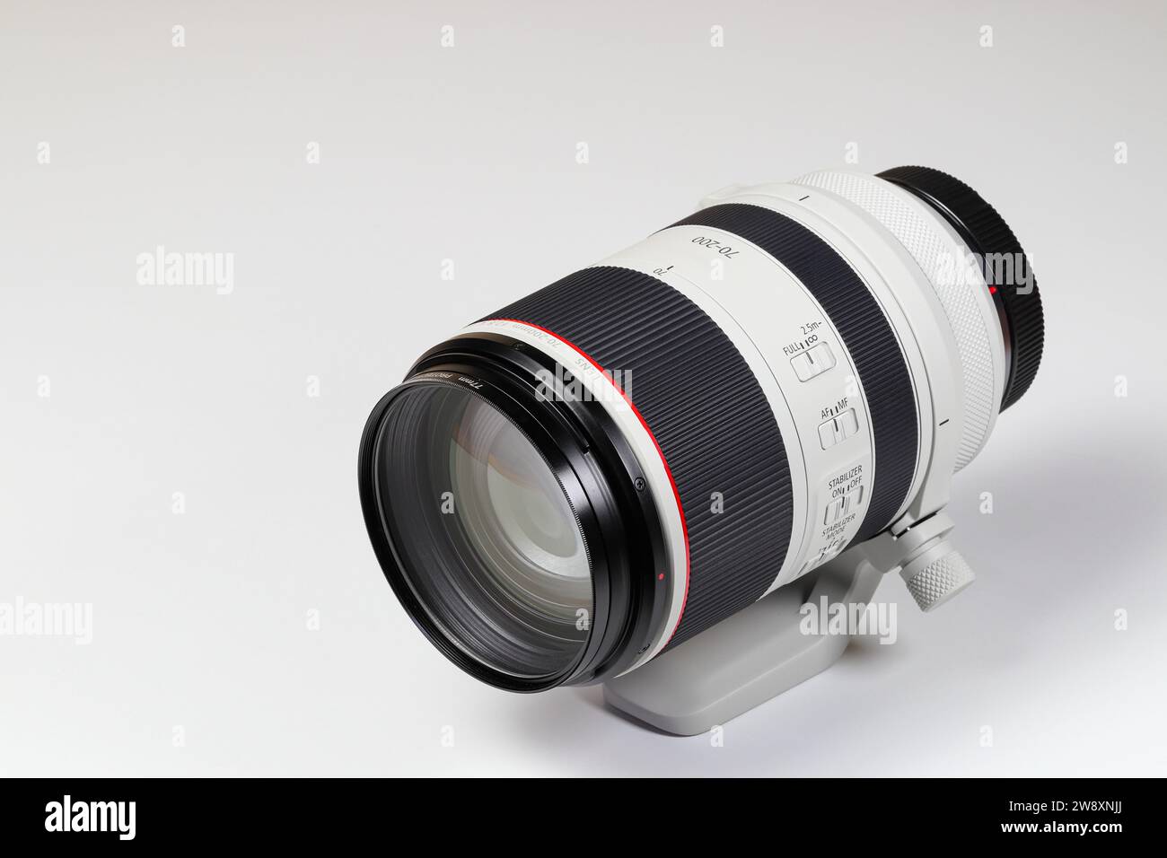 Leistungsstarkes professionelles Kamera-Zoomobjektiv mit komplizierten Objektivreflexionen, isoliert auf weißem Hintergrund. Stockfoto